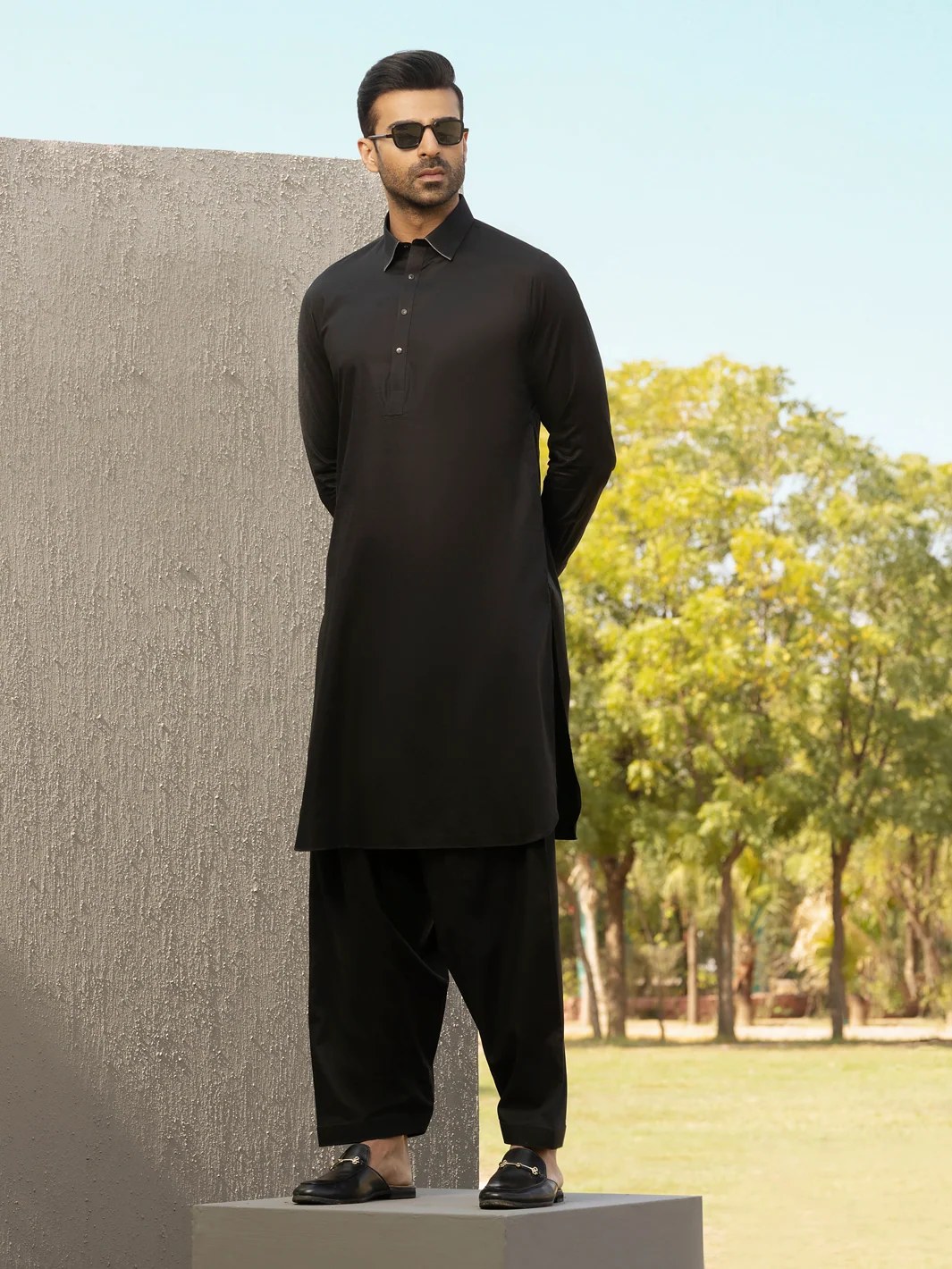 Man wearing a black Wajd kurta shalwar outdoors